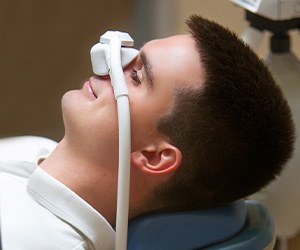 Patient relaxing while breathing in nitrous oxide in treatment chair