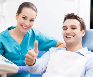 Man in dental chair giving thumbs up