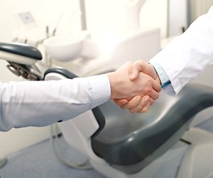Dentist and patient shaking hands