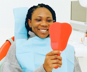 Woman looking in mirror at dentist