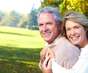 An older couple smiling outside.