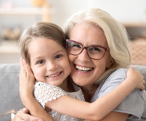 person smiling and hugging their grandchild