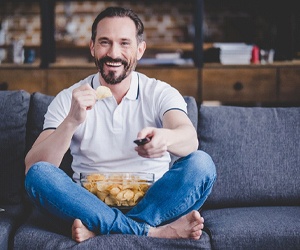 person eating potato chips on the couch