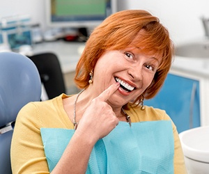 Senior woman pointing to smile