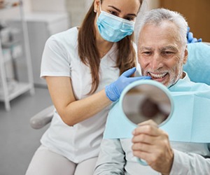 a patient checking his smile with a mirror