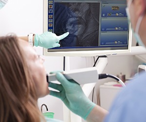 Woman and dentist looking at intraoral photos