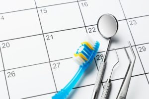 toothbrush and other dental tools resting on calendar 