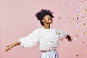 young woman celebrating the new year against a light pink background 