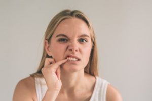 Woman inspecting her mouth for signs of gum disease.
