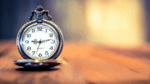 Pocket watch sitting open on a wood desk