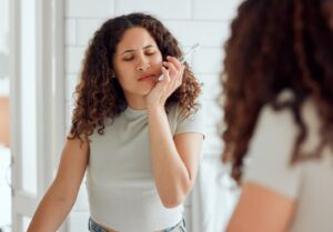 woman brushing her teeth while experiencing pain